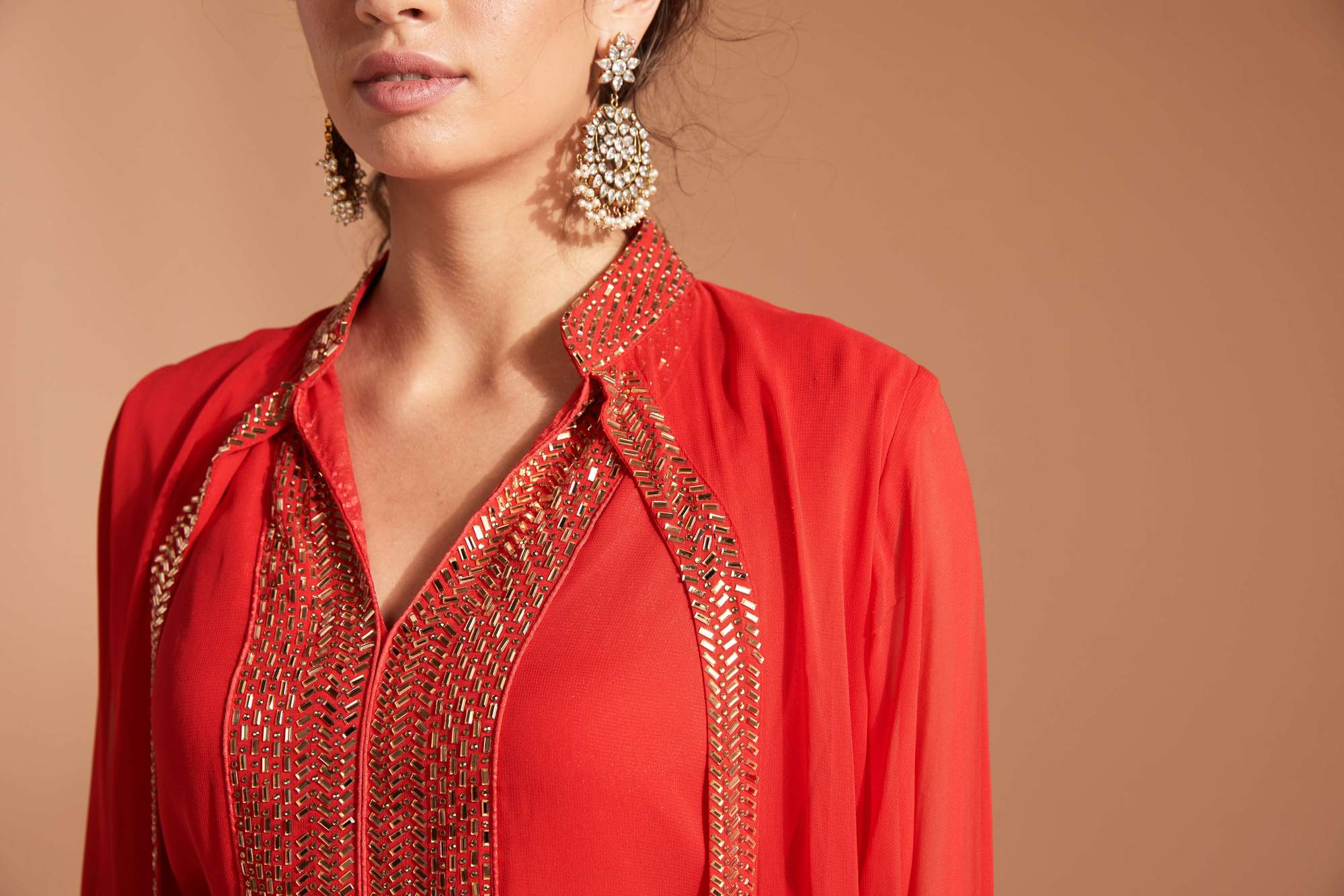Red outfit with sequin work paired with beautiful Indian jewel earring