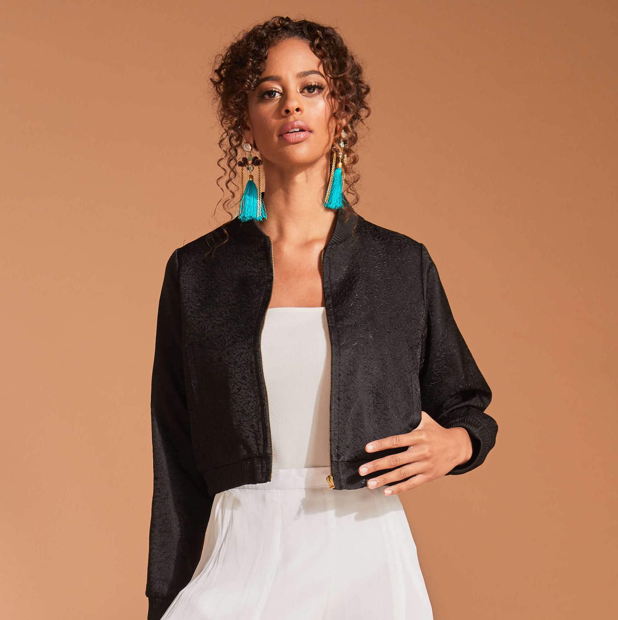 Black bomber jacket with turquoise earrings