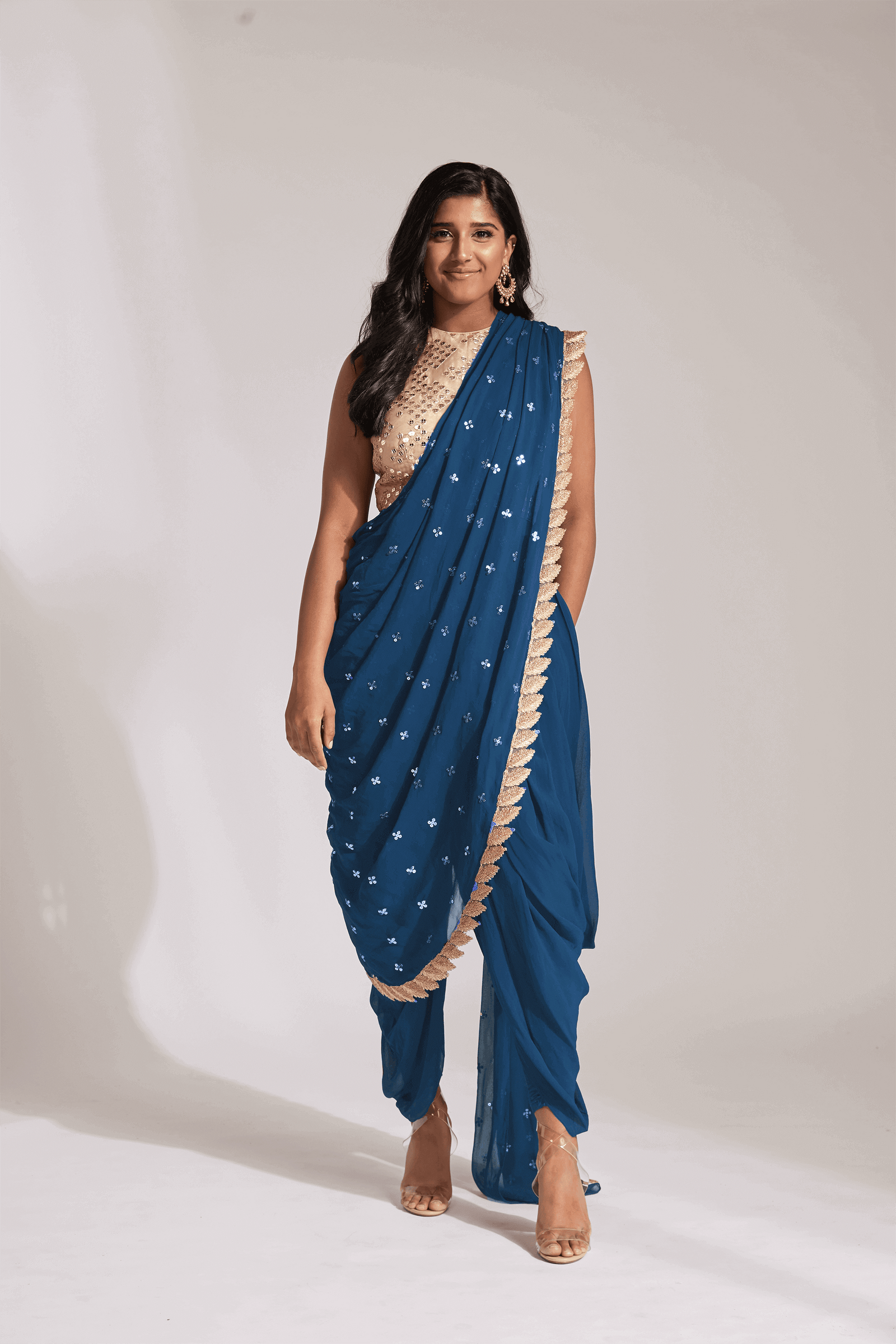 Blue dhoti pant outfit with attached drape and nude mirror work halter-style blouse